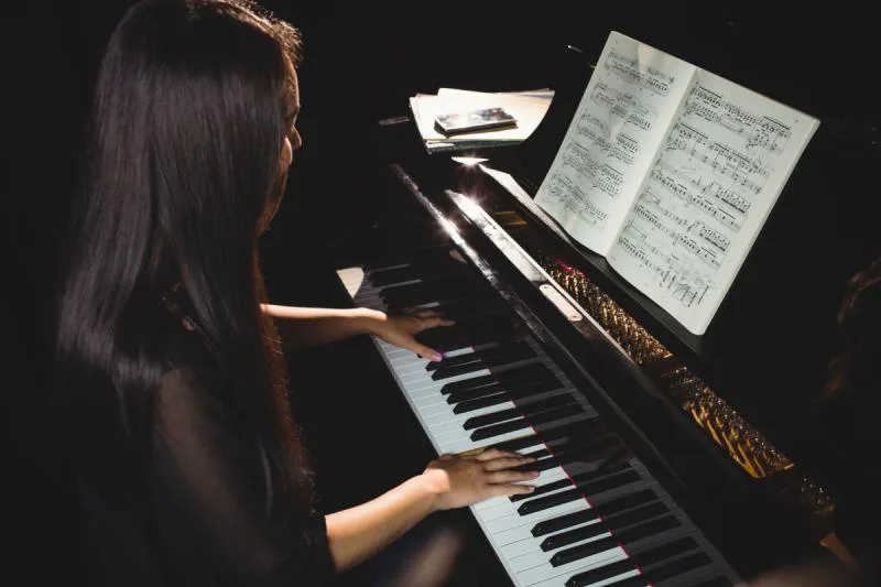 Women learning piano and reading sheet music.